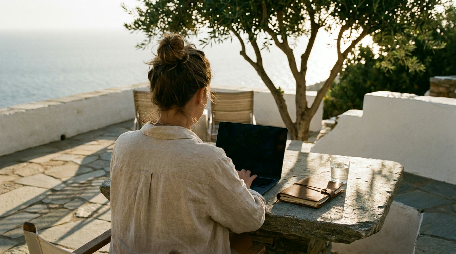 A writer working on a terrace above the sea